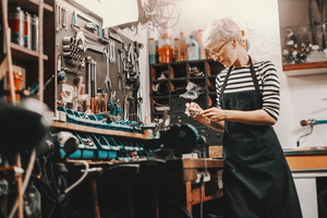 Handwerkerin steht an einer Werkbank